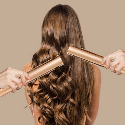 Frau mit langen, welligen Haaren, die mit einem goldenen Glätteisen gestylt werden.