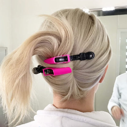 Frau mit blonden Haaren, befestigt mit pinken Haarklammern, im Badezimmer vor dem Spiegel.