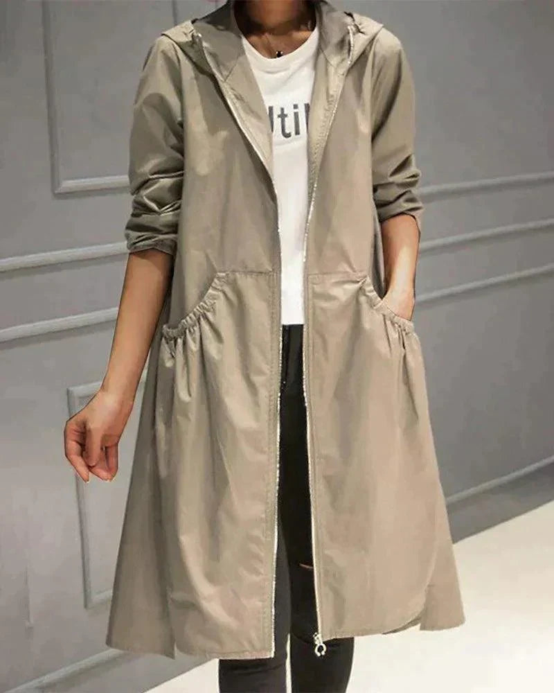 Frau trägt den offenen Regenmantel in Beige mit Kapuze, Reißverschluss und gerafften Eingrifftaschen über weißem Shirt 1