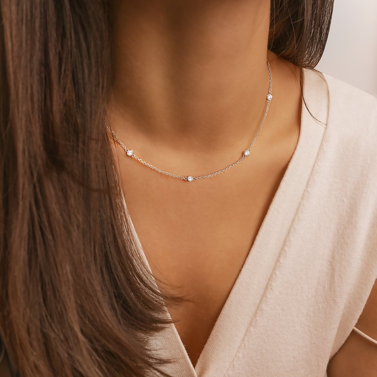 Frau mit silberner Halskette, zarte Kette mit kleinen Perlen, eleganter Schmuck, Nahaufnahme.