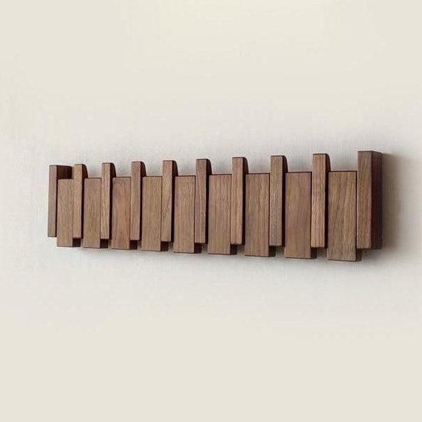 Frontansicht der dunklen Holzleiste mit eingeklappten Haken an einer hellen Wand 4