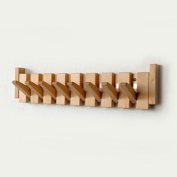 Helle Holzleiste mit allen Haken schräg ausgeklappt, von vorn an der Wand fotografiert 6