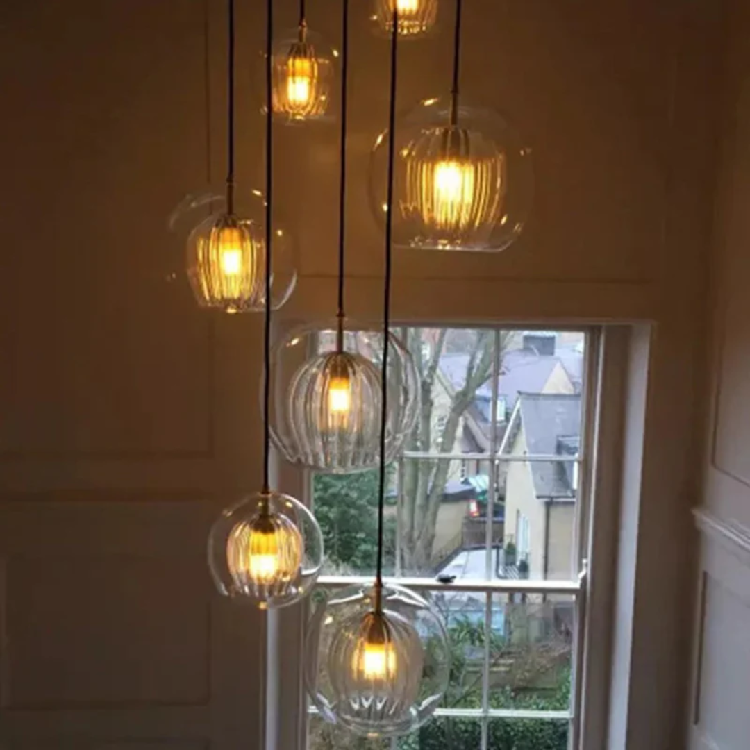 Hängelampe mit mehreren Glaskugeln, warmes Licht, modernes Design, Wohnzimmerbeleuchtung.