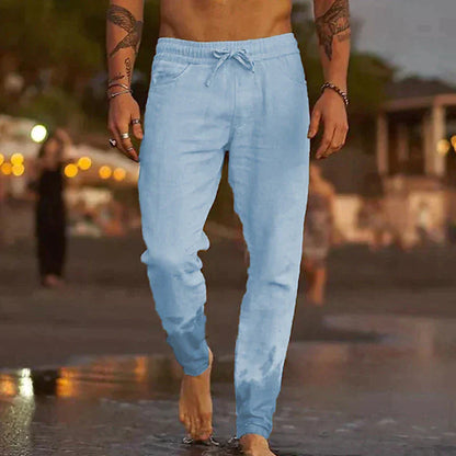 Mann in hellblauer Jogginghose am Strand, Freizeitmode, Sommerkleidung, Herrenbekleidung.