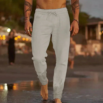 Mann in grauer Jogginghose am Strand, Freizeitmode, Herrenbekleidung, Sommeroutfit.