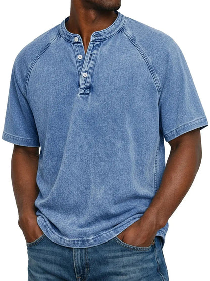 Mann trägt das ausgewaschene Henley-Shirt mit Raglanärmeln in Hellblau, kombiniert mit Jeans, Frontansicht mit Knopfleiste. 2