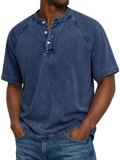 Mann trägt das ausgewaschene Henley-Shirt mit Raglanärmeln in dunklem Marineblau, Frontansicht mit drei Knöpfen am Ausschnitt. 3