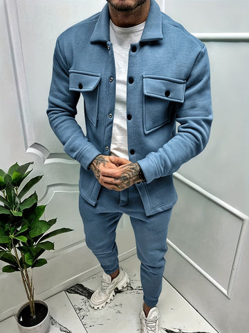 Mann in blauer Trainingsanzugjacke und Hose, weiße Sneakers, moderne Herrenmode.
