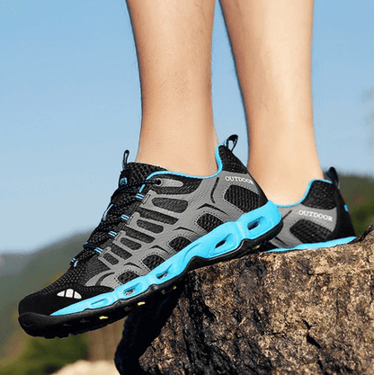 Schwarze und blaue Outdoor-Sportschuhe auf Felsen, atmungsaktiv, rutschfest, Herren.