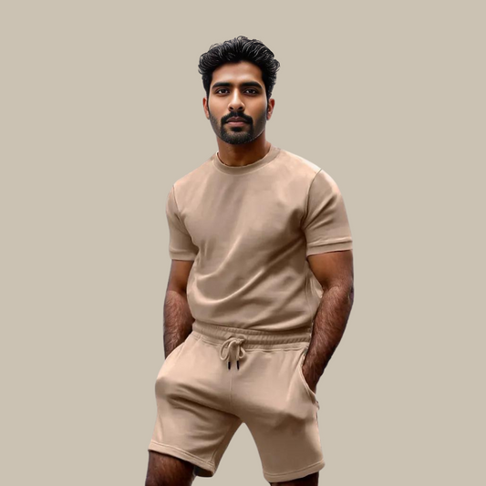 Mann in beigem T-Shirt und Shorts, Freizeitkleidung, Sommermode, neutraler Hintergrund.