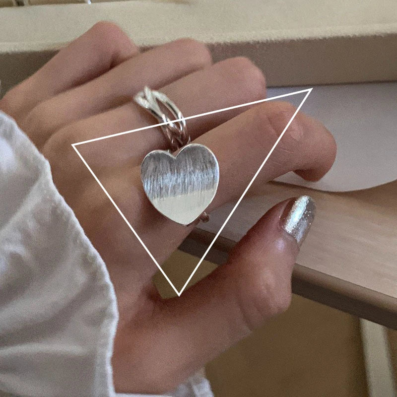 Silberner Herzring an Hand, modisches Accessoire, elegantes Schmuckdesign, Damenmode.