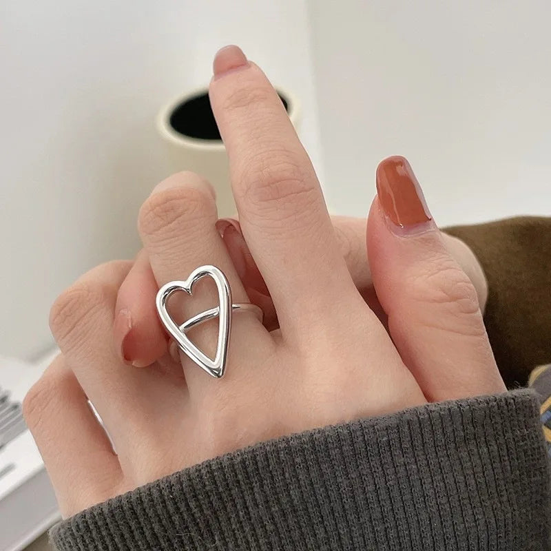 Silberner Herzring an Hand, minimalistisches Design, Modeschmuck, Damenaccessoire.