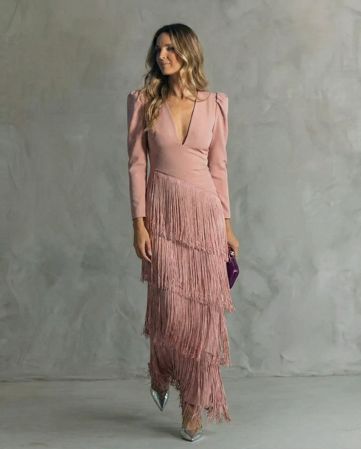 Das Kleid in Rosa mit gestuftem Fransenrock und langen Ärmeln, getragen von einem Model 7