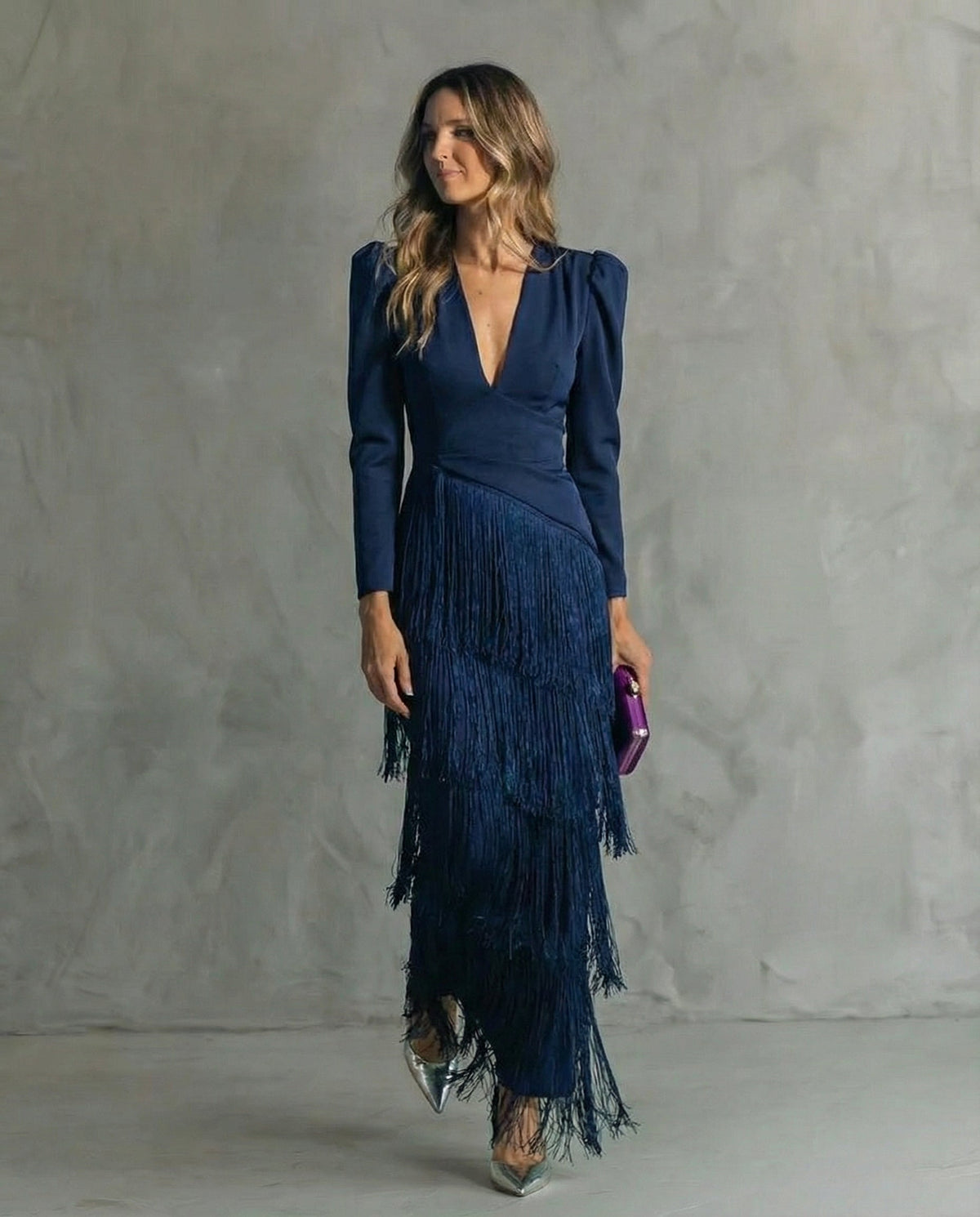 Das Kleid in Marineblau mit tiefem V-Ausschnitt und fließenden Fransenlagen, getragen von einem Model 6