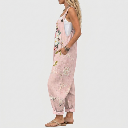 Seitenansicht des Models in der weiten rosa Latzhose, Hand in der Seitentasche, Blumenmuster und umgeschlagener Beinsaum sichtbar. 3