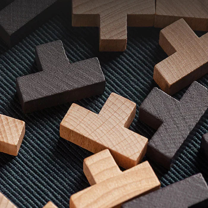 Holz-Puzzle-Teile auf Stoff, naturbelassen und schwarz, Spielzeug, Denkspiel, Nahaufnahme.