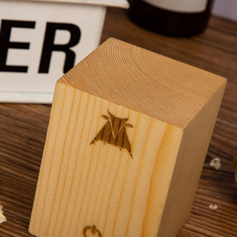 Holzwürfel mit eingraviertem Logo, helles Holz, glatte Oberfläche, Dekoration, Tischaccessoire.