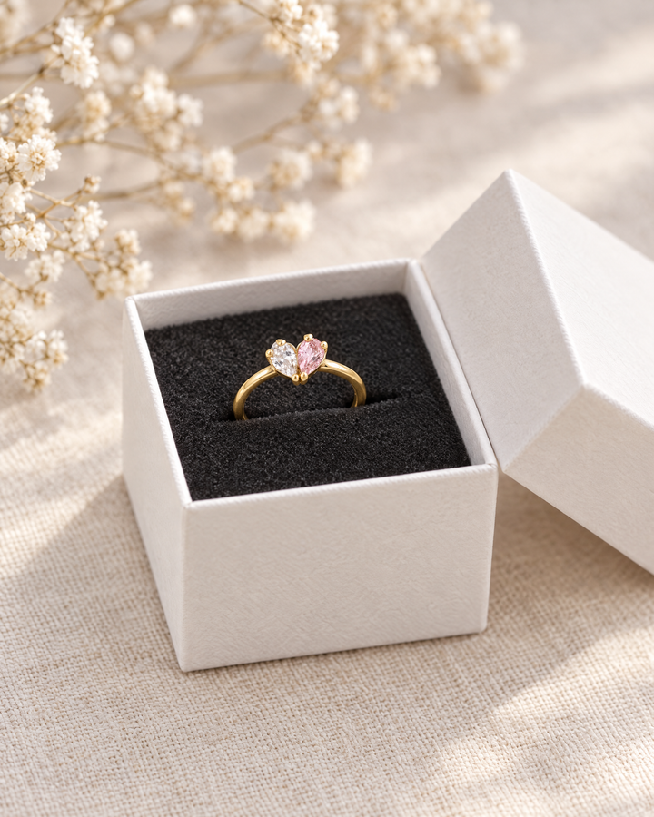 Der Ring in einer offenen weißen Schmuckschachtel mit schwarzem Schaumstoff, daneben getrocknete Schleierkraut-Zweige. 3
