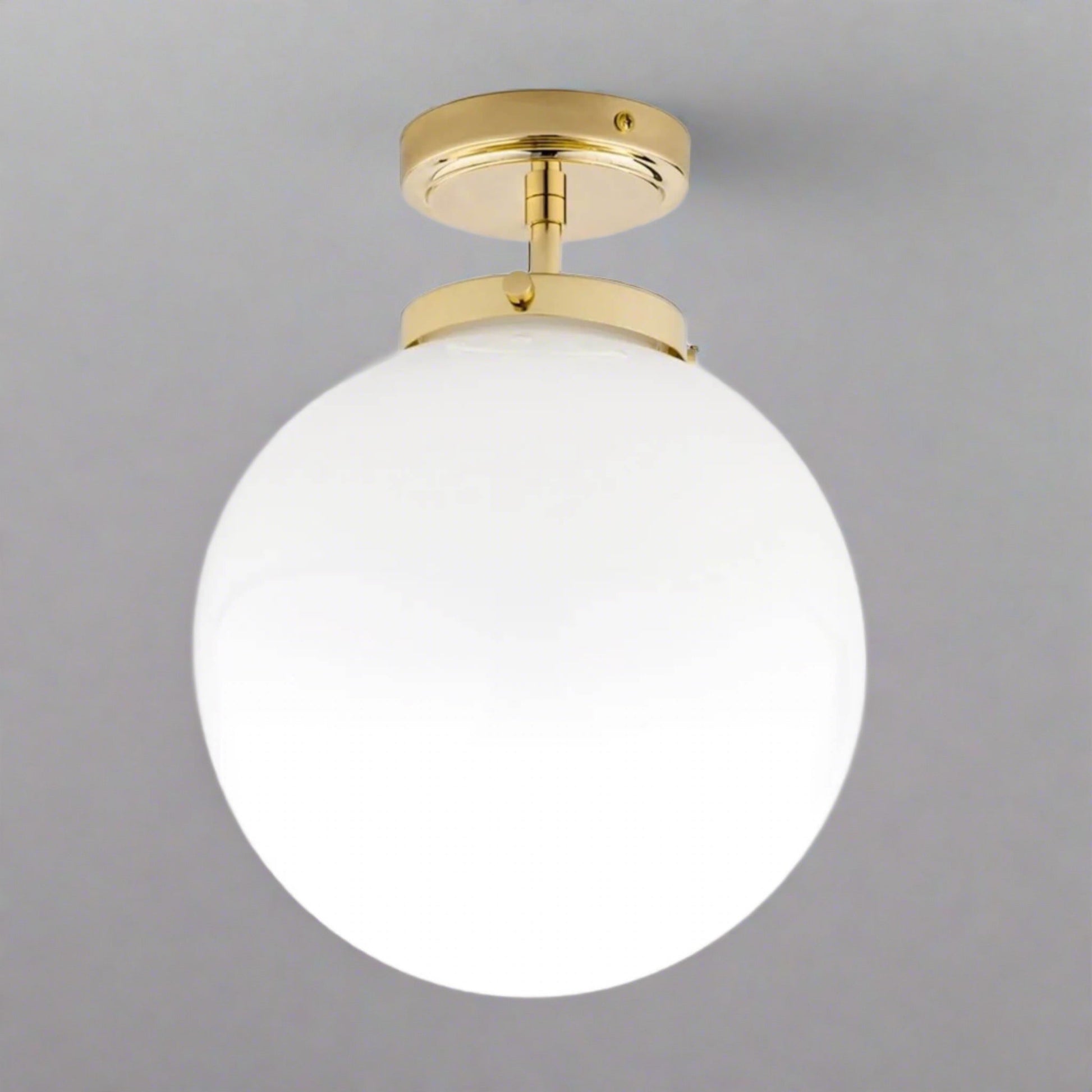 Goldene Deckenleuchte mit weißem Glaskugel-Schirm, modernes Design, ideal für Badezimmer.