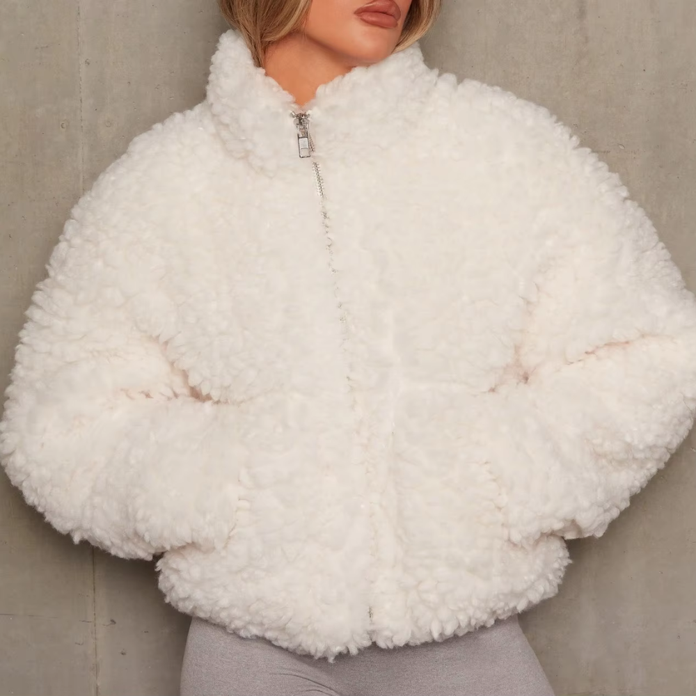 Frau in weißer Teddyfelljacke, Reißverschluss, modisch, warm, Winterkleidung, Damenmode.