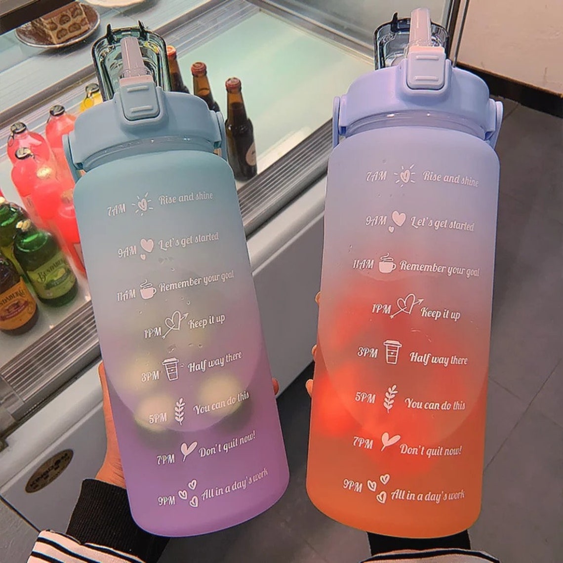 Zwei bunte Wasserflaschen mit Zeitmarkierungen und motivierenden Sprüchen, 2 Liter, Kunststoff.