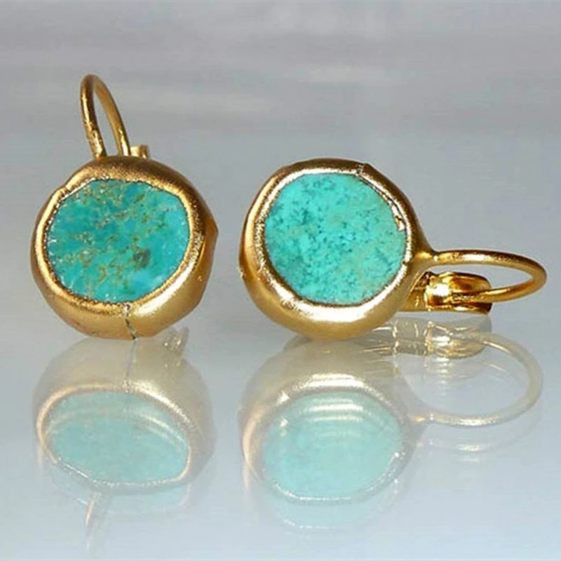 Goldene Ohrringe mit türkisfarbenem Stein, eleganter Schmuck, modisches Accessoire.