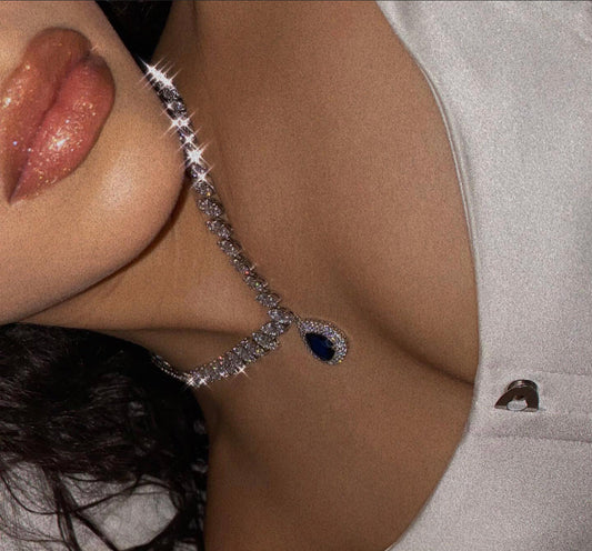 Funkelnde Diamantkette mit blauem Tropfenanhänger, eleganter Schmuck, Nahaufnahme.