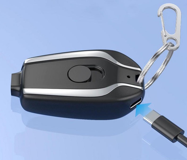 Schwarzer USB-C-Schlüsselanhänger mit Karabinerhaken auf blauem Hintergrund.