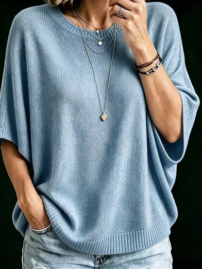 Nahaufnahme des hellblauen Strickoberteils mit weichem Maschenbild, getragen mit mehreren Halsketten, Armbändern und Hand am Kinn. 12