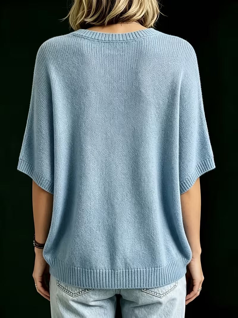 Rückansicht des hellblauen Strickoberteils mit Rundhalsausschnitt, gerippten Ärmelbündchen und Saum, getragen mit heller Jeans. 14