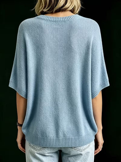 Rückansicht des hellblauen Strickoberteils mit Rundhalsausschnitt, gerippten Ärmelbündchen und Saum, getragen mit heller Jeans. 14