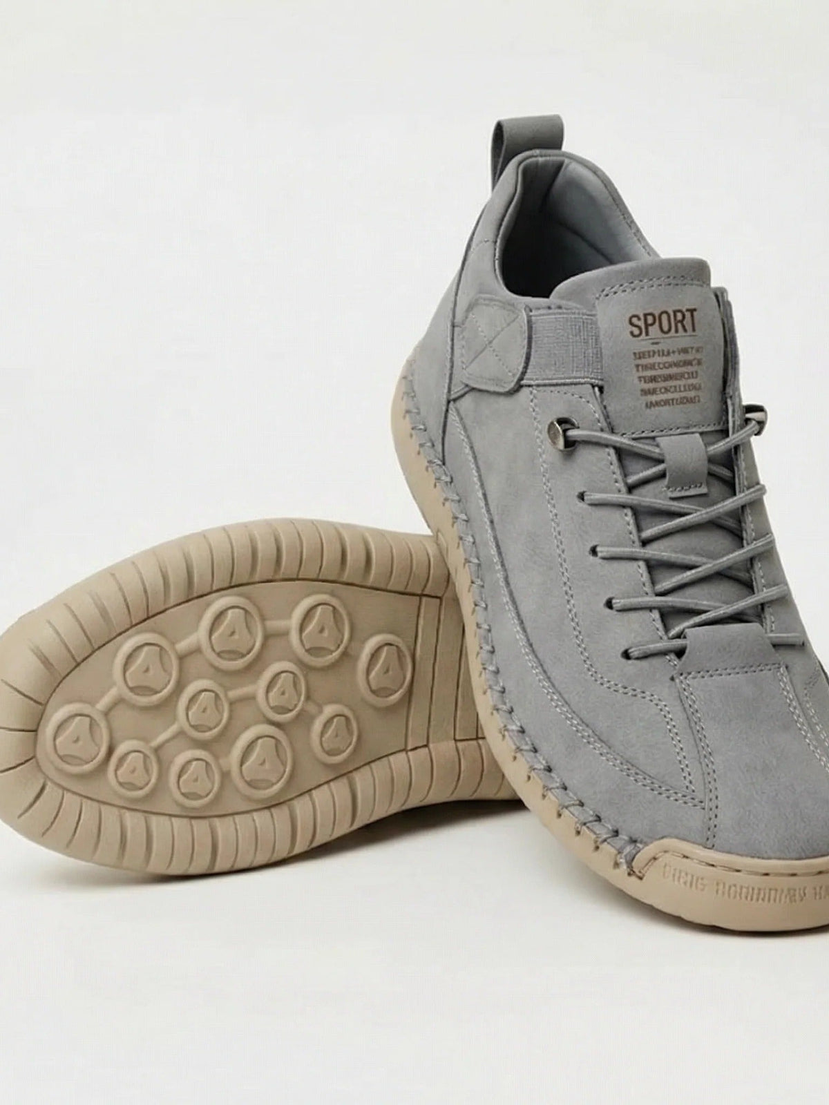 Graue Wildleder-Sneaker mit grauen Schnürsenkeln, daneben die beige Sohle mit rundem Noppenmuster 17
