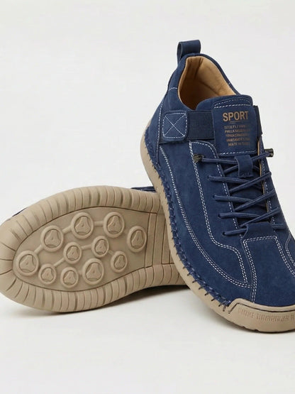 Marineblaue Wildleder-Sneaker mit heller Naht, daneben die beige Sohle mit Noppenprofil 2