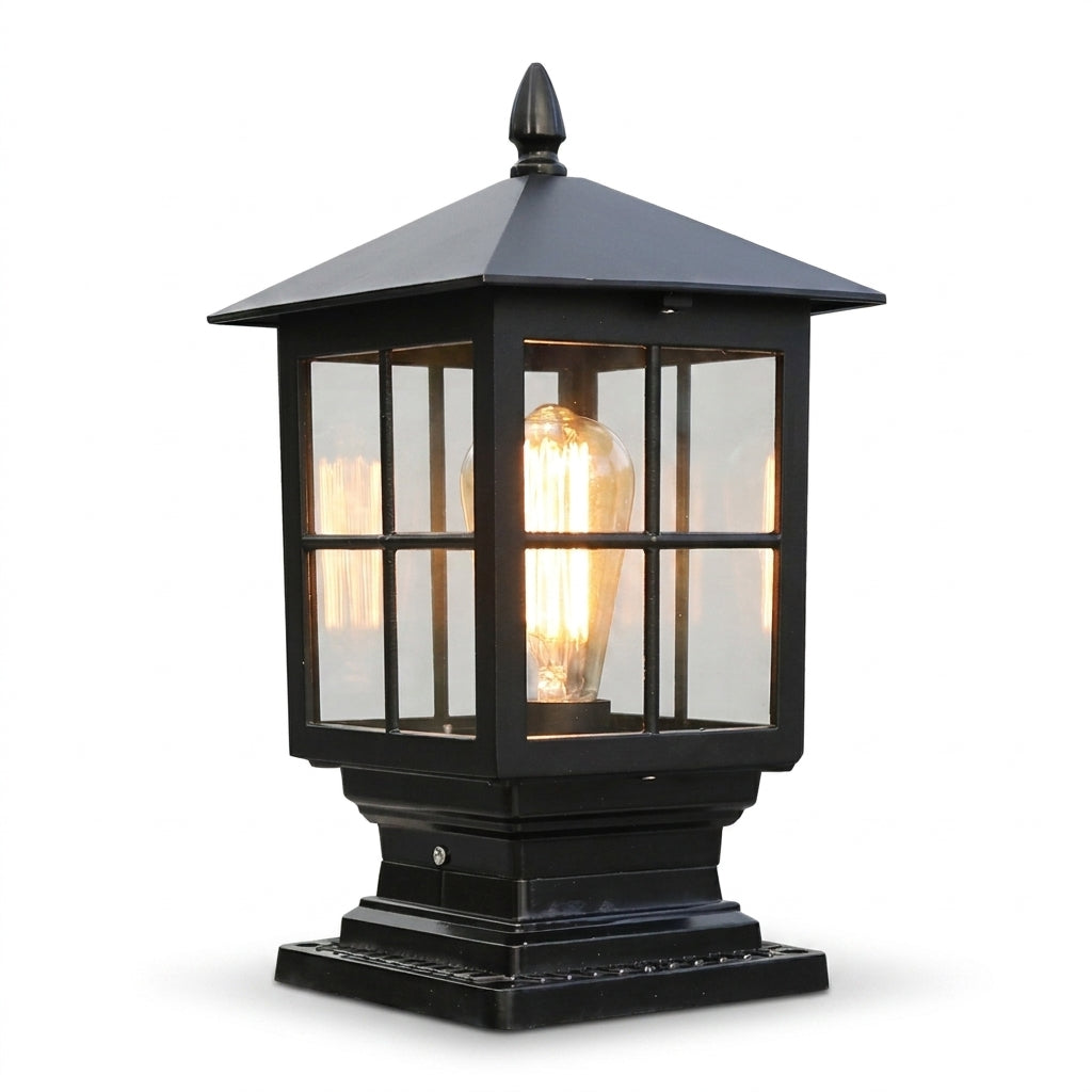 Schwarze Säulenleuchte mit Pyramidendach, Glasscheiben mit Sprossen und leuchtender Glühfadenlampe, freigestellt vor weißem Hintergrund. 1