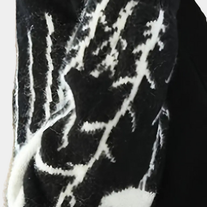 Schwarz-weißer Wollschal mit abstraktem Muster, warmes Winteraccessoire, modisch und elegant.