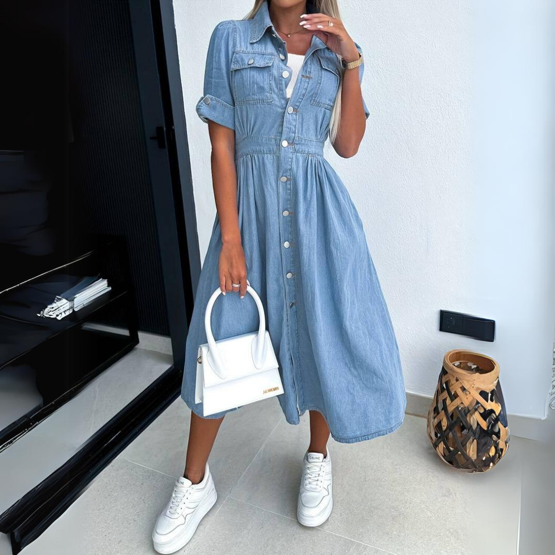 Frau in blauem Jeanskleid mit weißer Handtasche und Sneakers, moderne Mode, Innenraum.