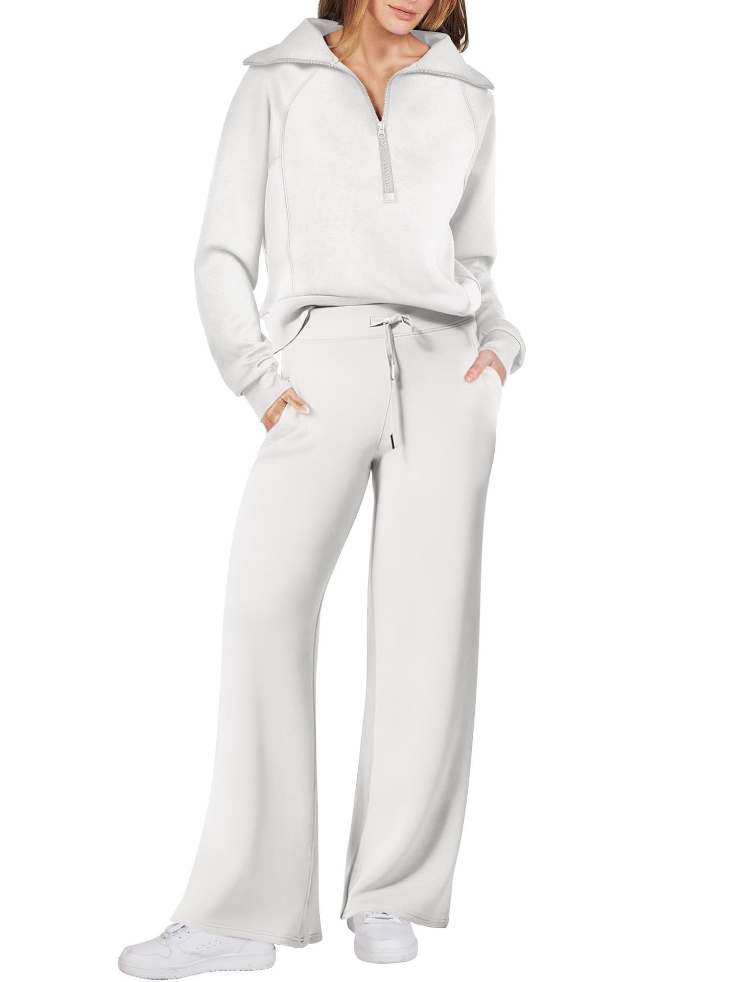Frau in weißem Jogginganzug mit Reißverschluss, weite Hose, Freizeitmode, bequeme Kleidung.
