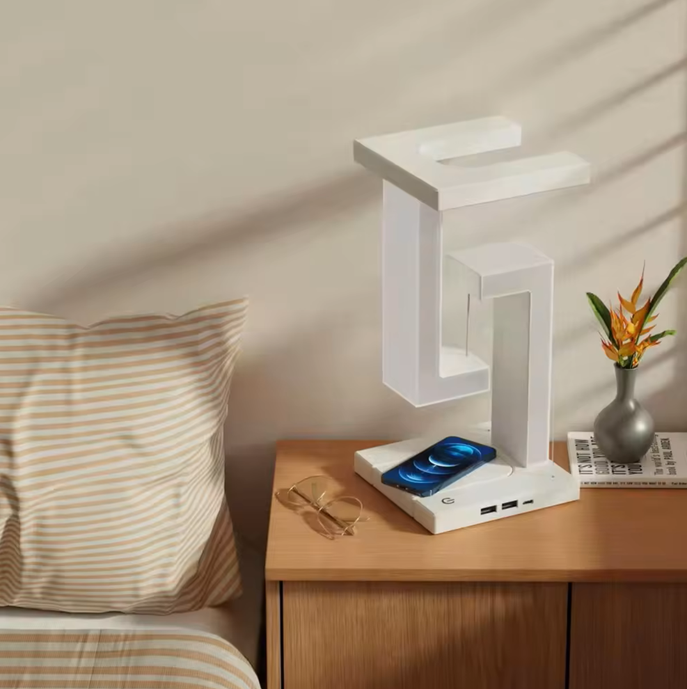 Moderne weiße LED-Tischlampe mit kabelloser Ladestation auf Nachttisch, minimalistisches Design.