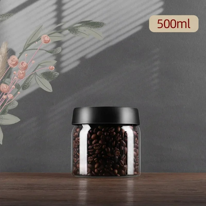 Glasbehälter mit schwarzem Deckel, gefüllt mit Kaffeebohnen, 500ml, auf Holztisch.