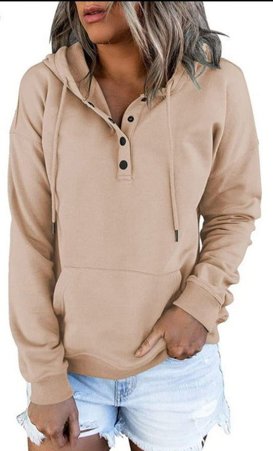 Frau in beigem Kapuzenpullover mit Knöpfen und blauen Jeansshorts, lässige Damenmode.