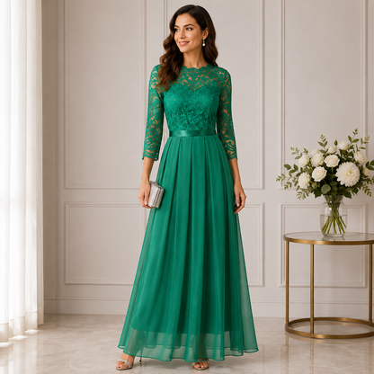 Frau im smaragdgrünen Abendkleid mit Spitzenoberteil, Dreiviertelärmeln und Chiffonrock neben einem Blumenstrauß 1
