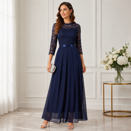 Frau im marineblauen Abendkleid mit Spitzenoberteil und fließendem Chiffonrock, silberne Clutch in der Hand 2