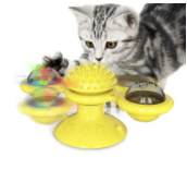 Graue Katze spielt mit gelbem interaktivem Katzenspielzeug mit rotierenden Kugeln.