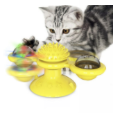 Graue Katze spielt mit gelbem interaktivem Katzenspielzeug, rotierend, mit bunten Lichtern.