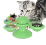 Graues Kätzchen spielt mit grünem interaktivem Katzenspielzeug mit rotierenden Kugeln.