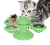 Graues Kätzchen spielt mit grünem interaktivem Katzenspielzeug mit rotierendem Ball.