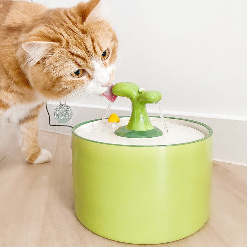 Rote Katze trinkt aus grünem Katzenbrunnen, Keramik, modernes Design, Haustierzubehör.