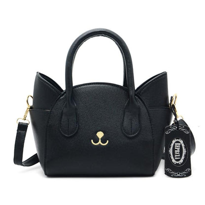 Schwarze Katzenhandtasche aus Leder mit abnehmbarem Schulterriemen und goldenen Details.