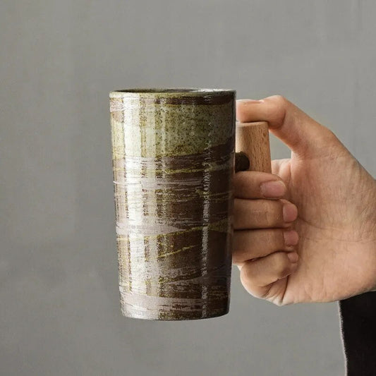 Handgefertigte Keramiktasse mit Holzgriff, braun-grün gestreift, ideal für Kaffee oder Tee.