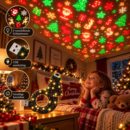 Ein lächelndes Mädchen im Schlafanzug liegt mit einem Teddy im Bett und blickt auf die bunten Weihnachtsmotive, die die Lampe an die Decke wirft. 6